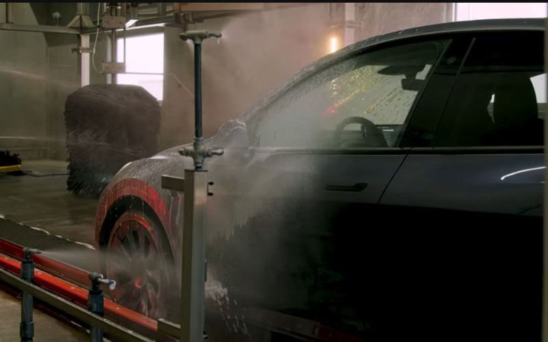 gray tesla going through car wash tunnel