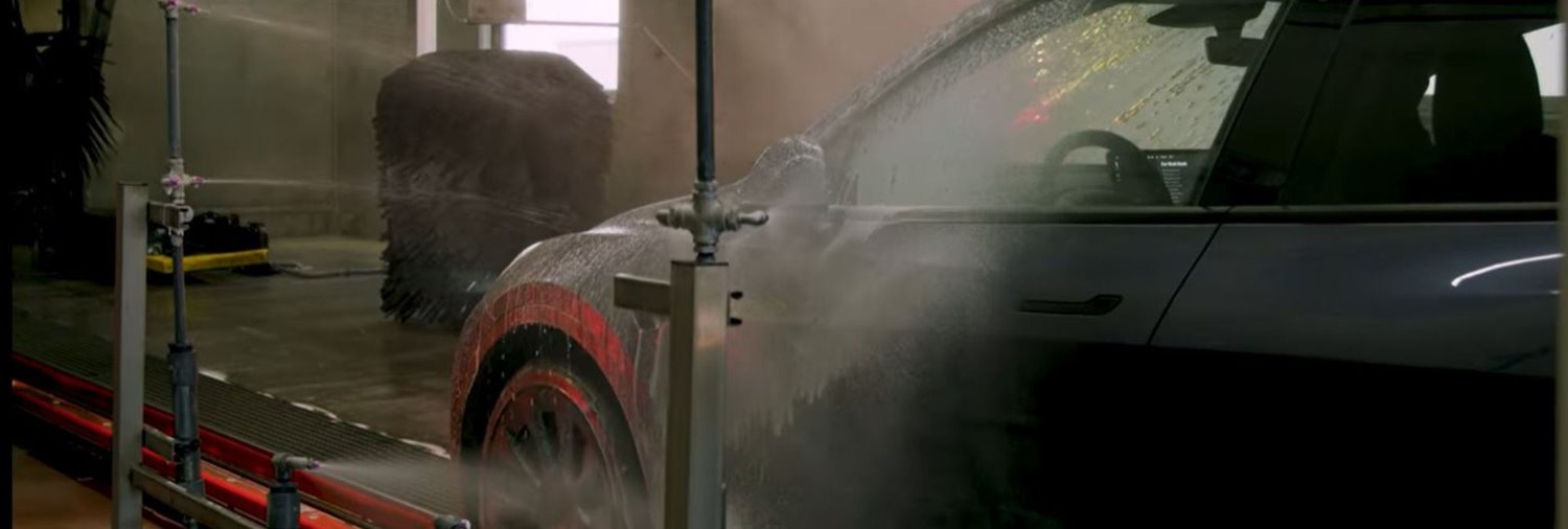 gray tesla going through tunnel car wash