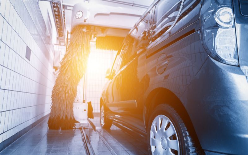 vehicle in a car wash bay with the sun shining at the exit