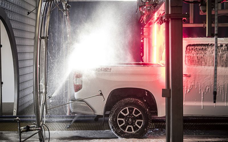 white pickup truck going through a car wash tunnel