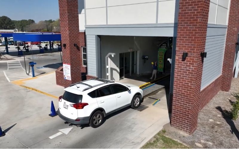 a white suv entering a car wash tunnel