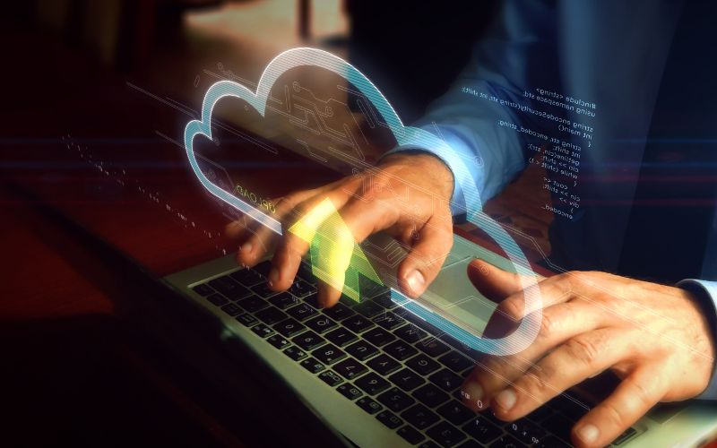 man's hands on a keyboard with a graphic of a cloud overlaid
