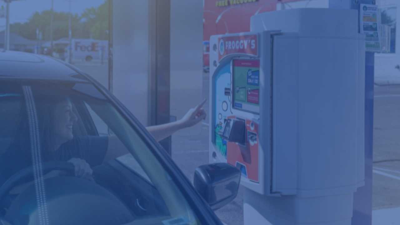 driver reaching out car window to pay station screen