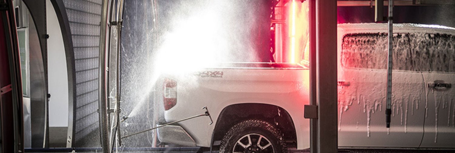 white pickup truck going through a car wash tunnel