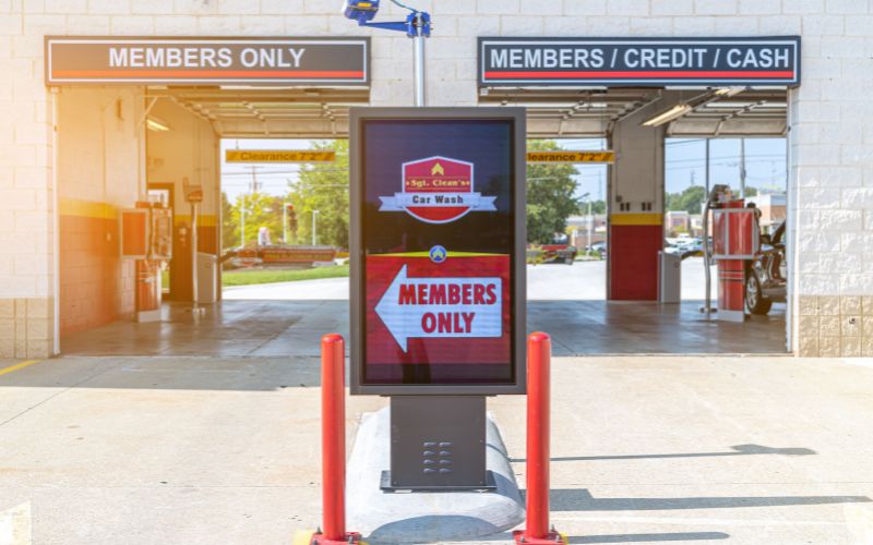 sign in front of car wash pay stations pointing to member lane