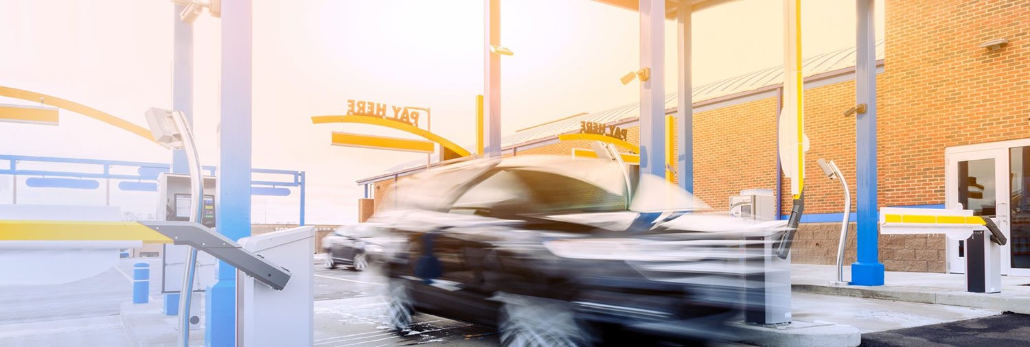 blurry car zooming through a car wash pay station lane