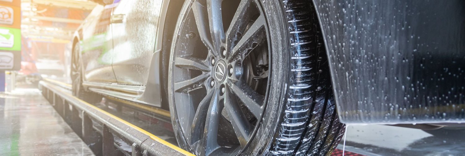 wheel of a car in a car wash conveyor track