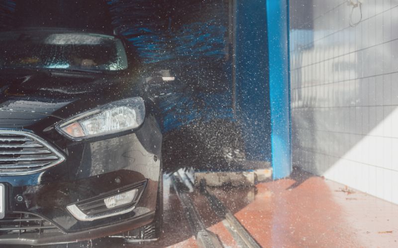 black car coming out of a car wash with wraps going