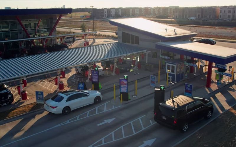 wide image  of cars going through lanes at car wash