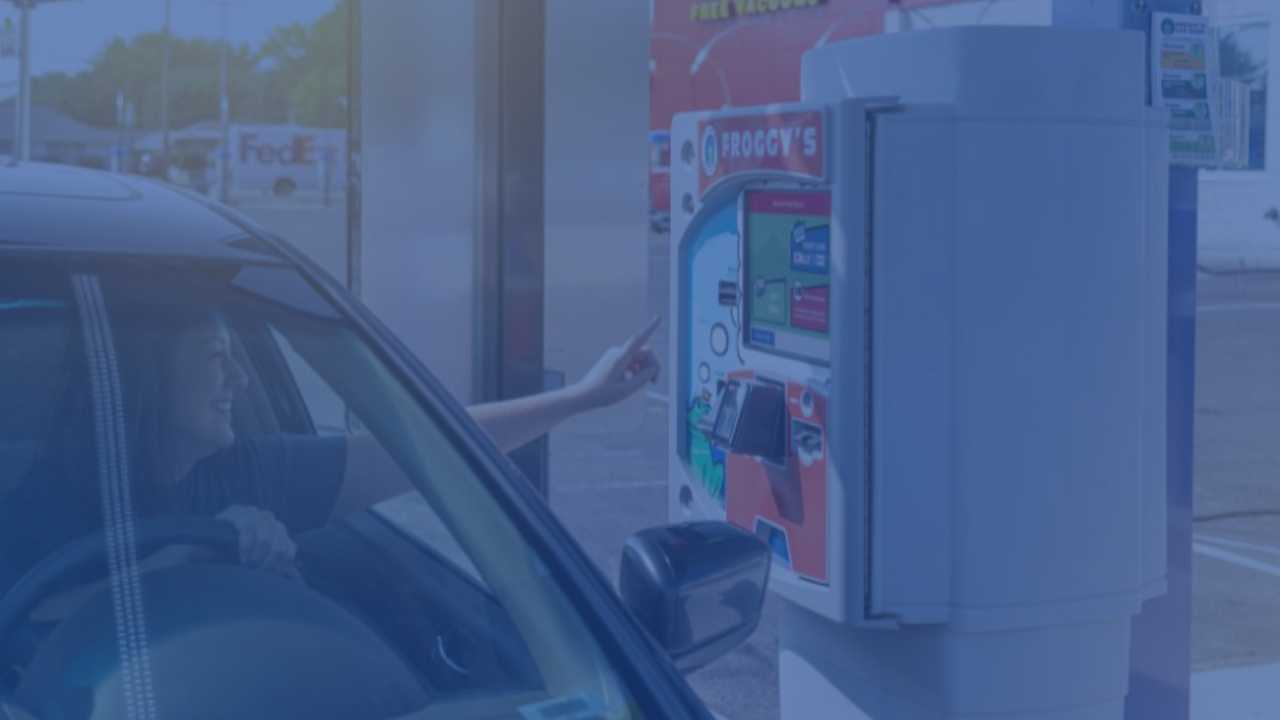 driver at car wash pay station smiling