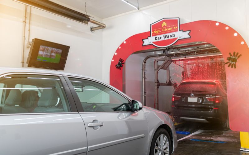 Two cars going into a car wash tunnel