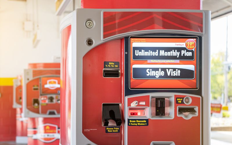 close up of xpt car wash pay station with two more xpts in the background